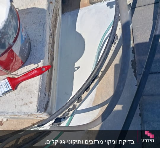 תמונה של גג עם מברשת צבע ודלי צבע
